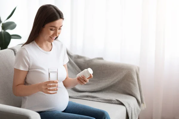 Suplemen Selama Kehamilan. Wanita hamil Memegang Jar Dengan Vitamin Dan Kaca Air — Stok Foto