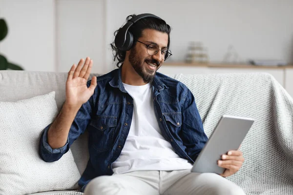 Communication en ligne. Homme arabe utilisant une tablette numérique à la maison, faire un appel vidéo — Photo
