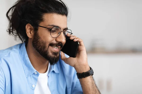 Gözlüklü ve diş telli gülümseyen genç bir Arap cep telefonuyla konuşuyor. — Stok fotoğraf