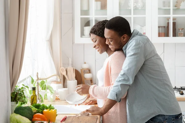 Romántica pareja negra platos de limpieza y la unión en la cocina — Foto de Stock