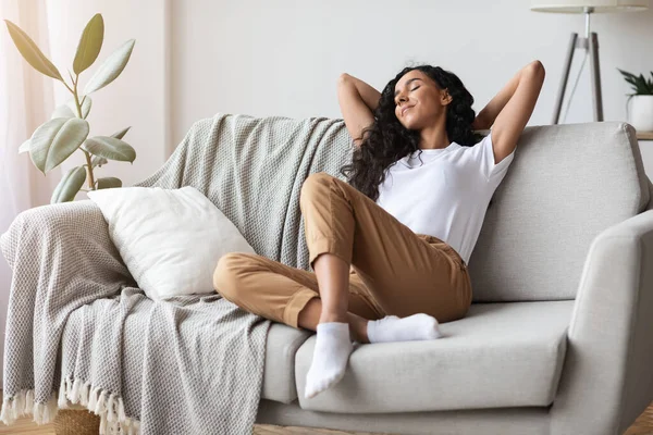Obekymrad ung kvinna vilar på soffan hemma — Stockfoto
