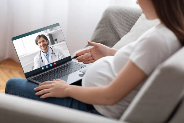Телемедицина. Невпізнавана вагітна леді, яка має онлайн-консультацію з лікарем на ноутбуці — стокове фото