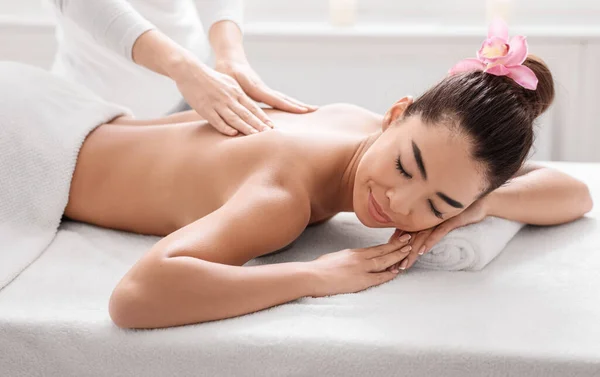 Aantrekkelijke Koreaanse dame krijgen professionele terug massage behandeling sessie in Spa Salon — Stockfoto