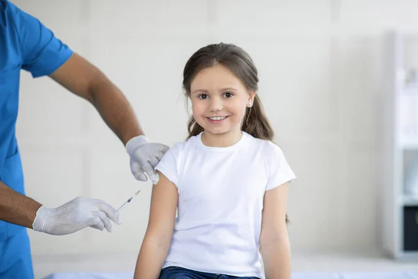 Médecin afro-américain faisant une injection de vaccin contre le coronavirus à une petite fille à la clinique, panorama — Photo