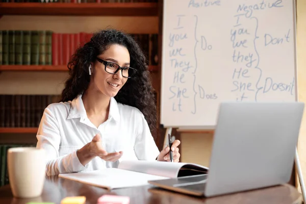 Senhora sentada à mesa, usando o computador para chamada de vídeo — Fotografia de Stock