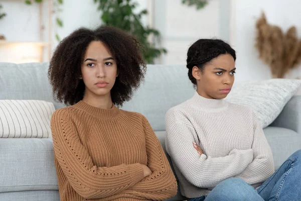 Conflito entre dois melhores amigos. Mulheres cruzaram os braços, sentadas no chão e olhando em lados diferentes — Fotografia de Stock