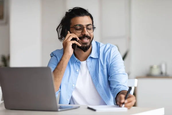 Jong Arabisch man ondernemer praten op mobiele telefoon en het nemen van notities in Office — Stockfoto