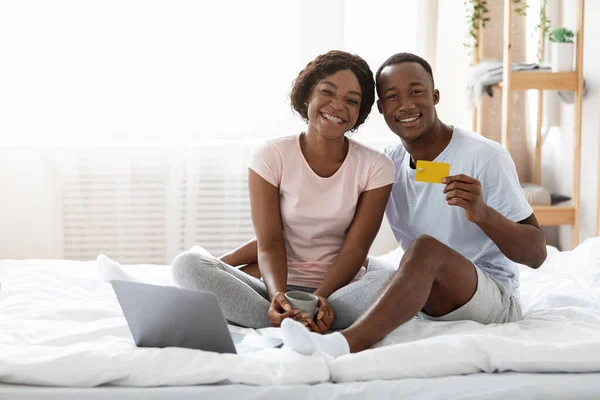 Vrolijke Afrikaanse man en vrouw met laptop met creditcard — Stockfoto