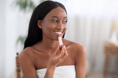Kozmetik, güzel dudaklar ve kış bakımı. Milenyum Afrikalı Amerikalı gülümseyen kadın mükemmel sağlıklı cilde sahip.