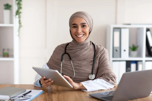 Dijital tablet kullanarak klinikte çalışan çekici kadın doktor. — Stok fotoğraf