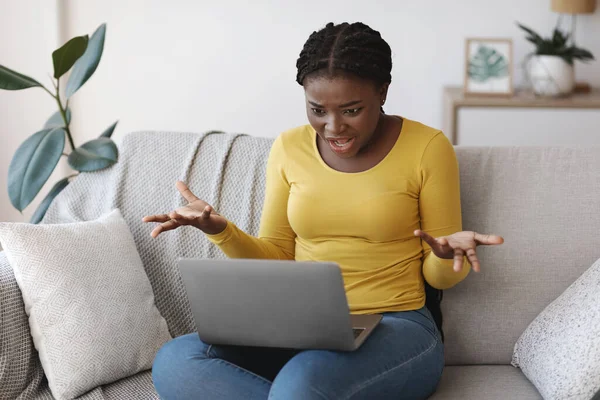 Frustrado afro-americano mulher sofrendo problemas com computador portátil em casa — Fotografia de Stock