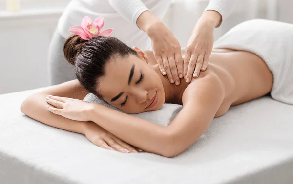 Lázeňská masáž. Mladá asijská žena relaxační zatímco profesionální terapeut masáž ramena — Stock fotografie