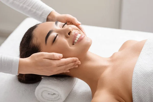 Jong glimlachen koreaanse vrouw genieten spa gezicht massage in schoonheid salon — Stockfoto