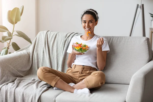 陽気な若い女性食べる野菜サラダに家 — ストック写真