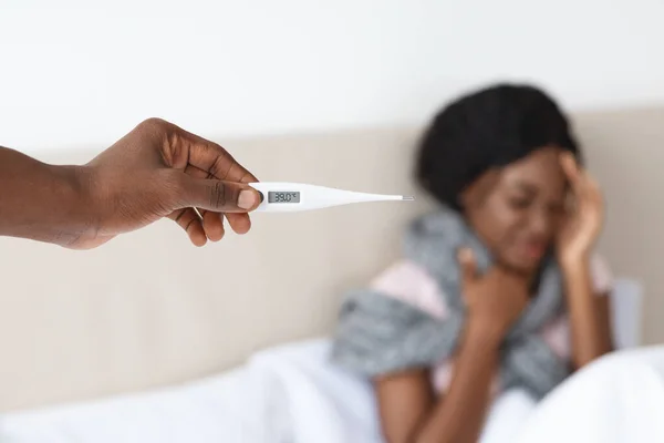 Schwarze Frau mit Fieber, Mann mit Thermometer — Stockfoto