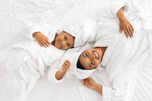 Top Άποψη της ευτυχούς Αφρικής μαμά και κόρη σε μπουρνούζια στο κρεβάτι — Φωτογραφία Αρχείου
