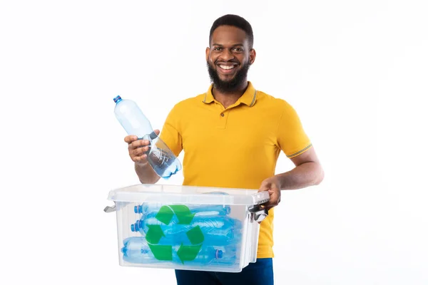 ペットボトルをリサイクルボックスに入れるアフリカ人男性,白の背景 — ストック写真