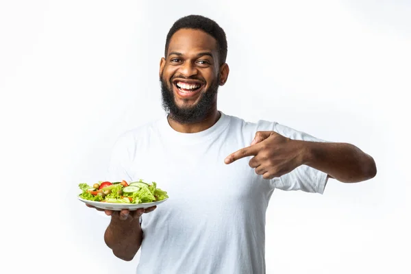 Glada svart kille pekar finger på sallad över vit bakgrund — Stockfoto