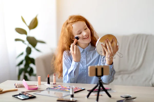 Menina adolescente de cabelos vermelhos gravando seu blog de beleza, fazendo maquiagem — Fotografia de Stock