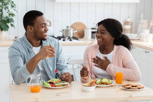 Jeune couple noir heureux ayant un petit déjeuner sain ensemble dans la cuisine à la maison — Photo