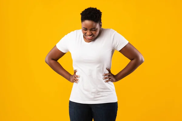 Overweight mulher negra com dor de estômago em pé sobre fundo estúdio amarelo — Fotografia de Stock
