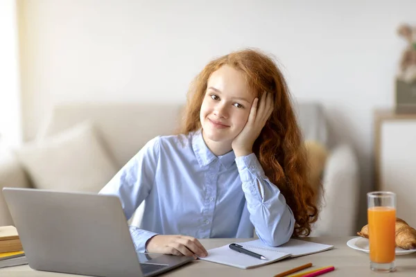 Menina sentada à mesa, usando laptop para e-learning — Fotografia de Stock