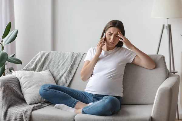 怀孕妇女在家用手机交谈时感到身体不适，头疼 — 图库照片