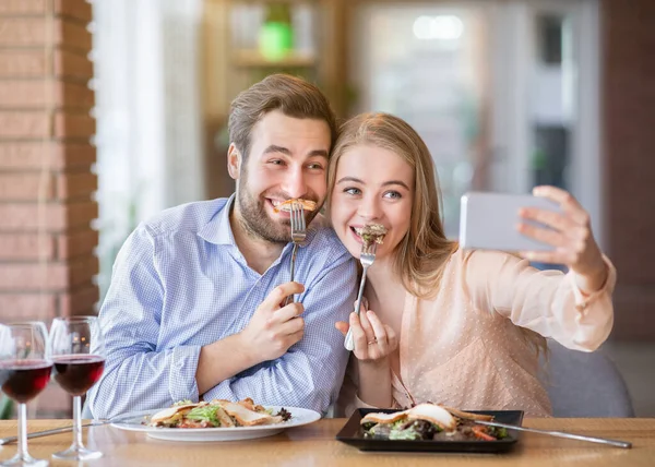 Couple millénaire stupide s'amuser pendant le dîner, prendre selfie au café urbain confortable — Photo