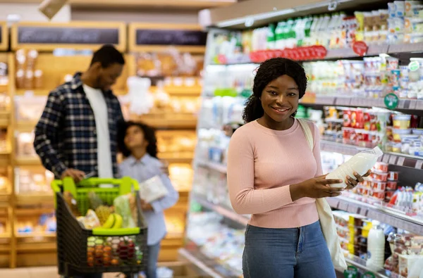 Keluarga kulit hitam yang bahagia dengan belanja anak untuk produk di supermarket bagian susu, ruang fotokopi — Stok Foto