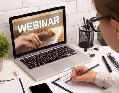 Genç bayan ofis çalışanı Webinar dinlerken not alıyor