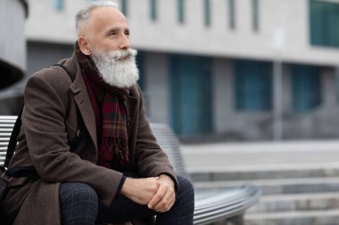 Ofisin yanındaki bankta oturan yakışıklı son sınıf öğrencisi.