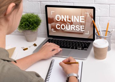 Ders çalışırken not defterine notlar yazan tanınmayan genç kadın tasarımcı.