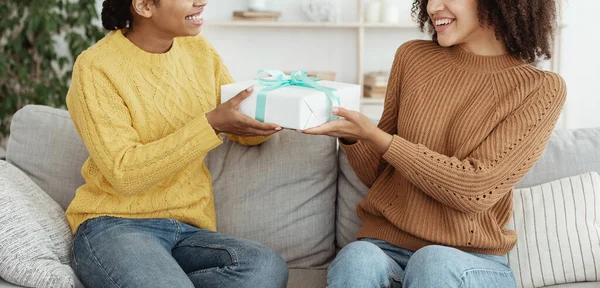 Delad julklapp, grattis på födelsedagen. Leende afrikansk amerikansk kvinna ger gåva till vän — Stockfoto