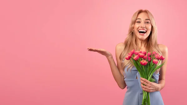 Belle jeune femme avec des fleurs de printemps célébrant la Journée des femmes, la publicité de votre produit sur fond rose, maquette — Photo