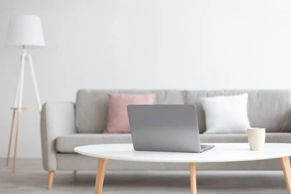 Modern scandinavian living room interior. Laptop on white table for work with cup — Stock Photo, Image