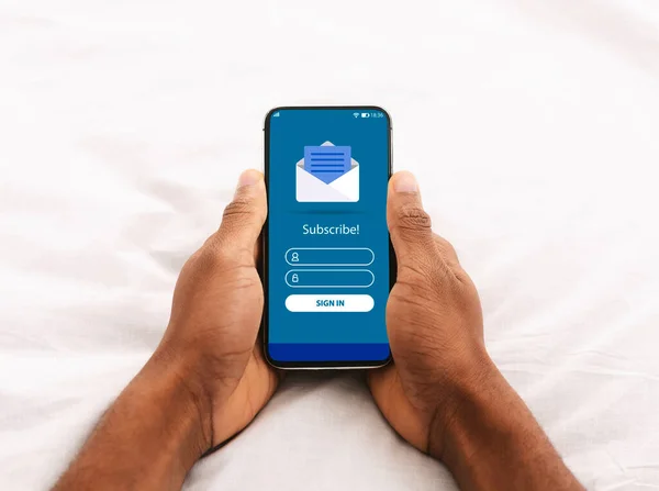 Digitális marketing. Black Man Holding Smartphone with Newsletter Subscription Form on Screen — Stock Fotó