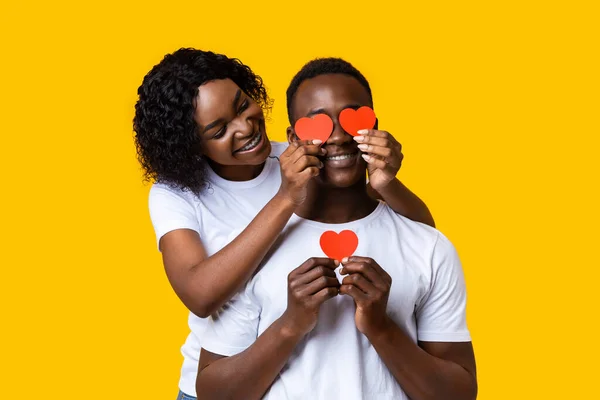Milující černošky žena zakrývající její přítel oči s valentýnskými kartami — Stock fotografie