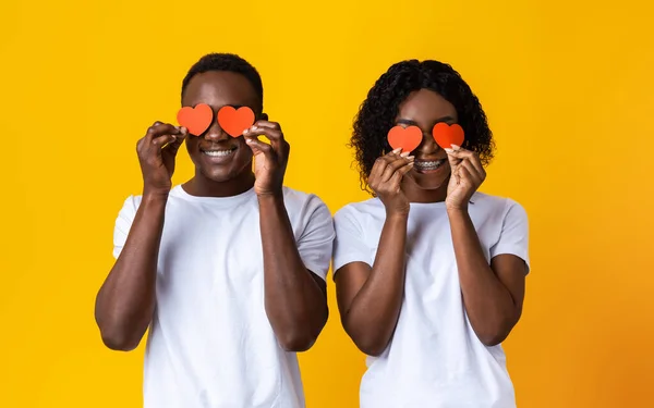 Uomo e donna di colore che coprono gli occhi con carte di San Valentino — Foto Stock