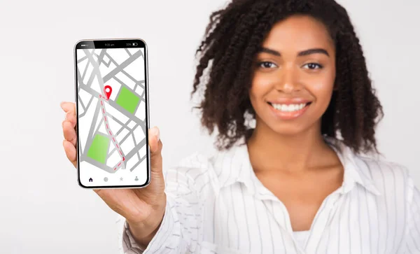 Μαύρη κυρία κρατώντας Smartphone με ανοιγμένα Gps πλοήγησης σε απευθείας σύνδεση χάρτες στην οθόνη — Φωτογραφία Αρχείου