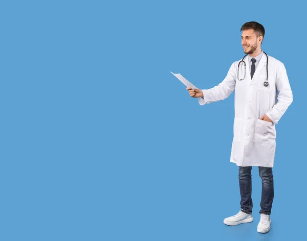 Mosolygós férfi orvos ajánló orvosi kezelés álló felett kék háttér — Stock Fotó