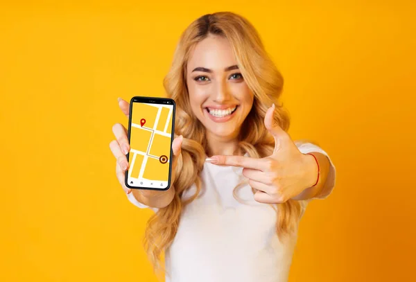 Femme joyeuse pointant sur Smartphone avec application de navigation GPS à l'écran — Photo