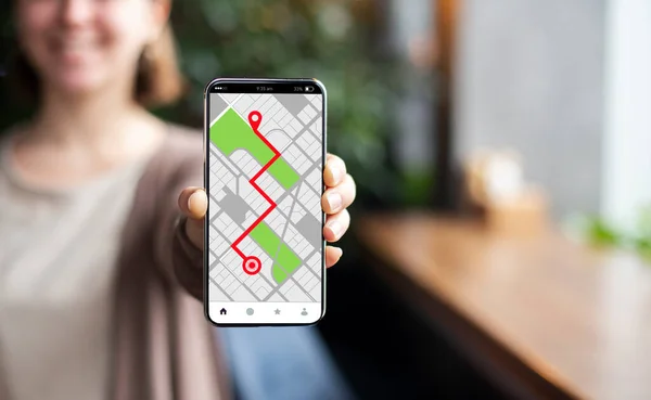 Smartphone με ανοιγμένα Gps πλοήγησης σε απευθείας σύνδεση χάρτες στην οθόνη στο γυναικείο χέρι — Φωτογραφία Αρχείου