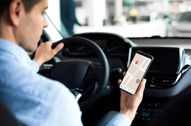 Adam Otomobil Merkezi 'nde oturan akıllı telefonu kullanıyor.