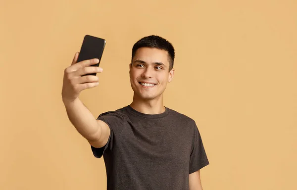 Modernt foto på gadget för blogg. Glada tusenåriga manliga student gör selfie — Stockfoto