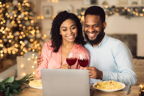 Svart man och kvinna som använder laptop dricka vin — Stockfoto