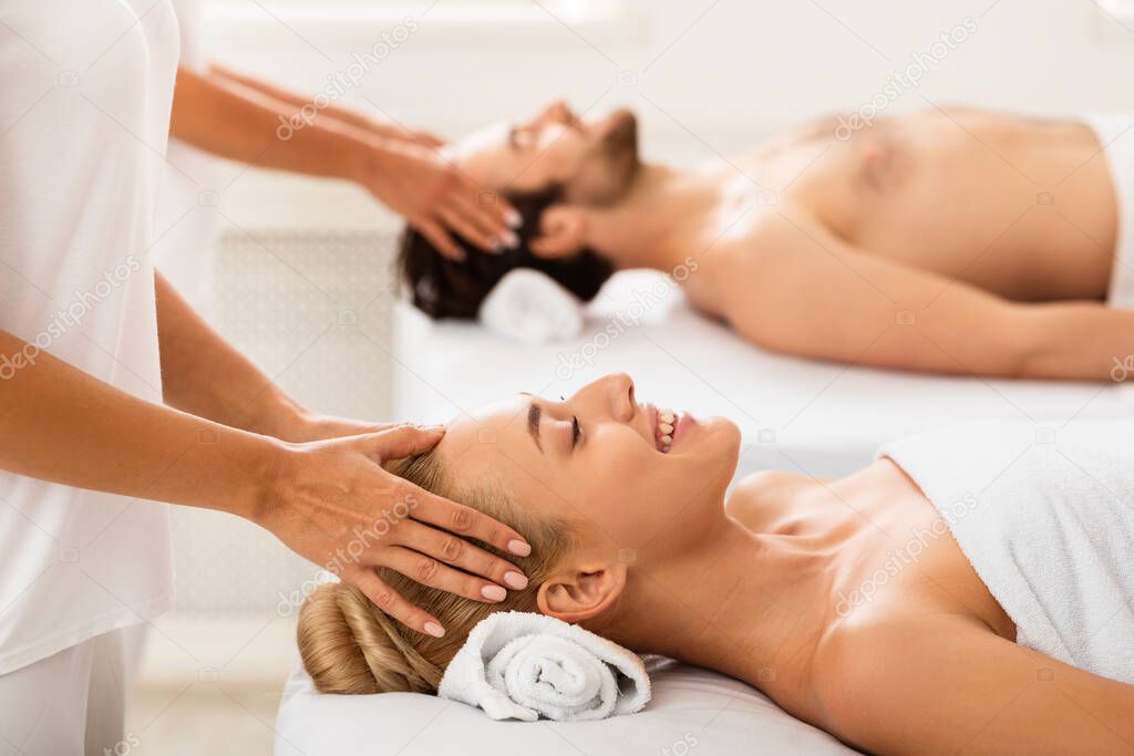 Couple Getting Relaxing Head Massage Together Lying Indoors