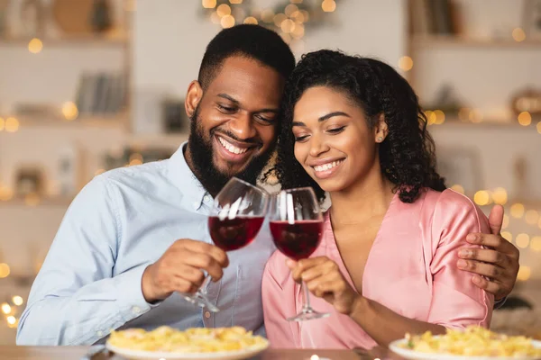 Leende svart kvinna och man dricker vin på en dejt — Stockfoto