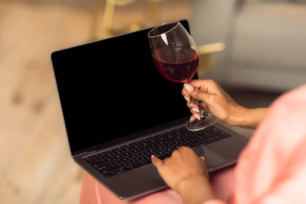 空のモックアップ画面とラップトップを使用して黒の女性,ワインを飲む — ストック写真