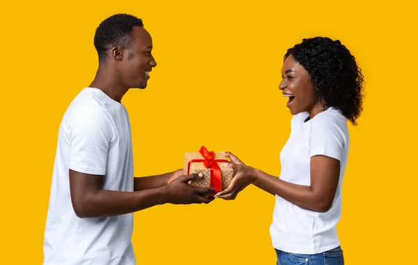 Feliz pareja negra dando regalo de San Valentín el uno al otro —  Fotos de Stock