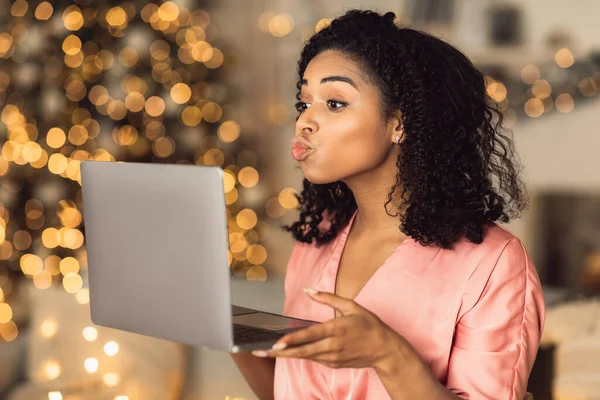 Afro woman blowing kiss during virtual date on laptop — Stock Photo, Image
